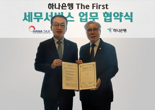 하나은행이 지난 19일 세무법인 하나와 'The First 서비스' 전문성 강화를 위한 업무 협약을 체결했다고 밝혔다. 사진은 협약식에서 업무협약 후 기념 촬영하는 김기석 하나은행 자산관리그룹 부행장(왼쪽)과 이규섭 세무법인 하나 대표이사. 연합뉴스.